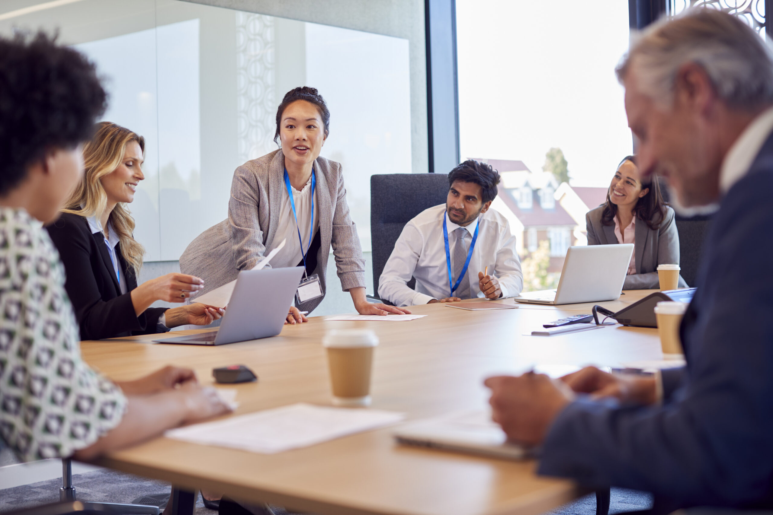 Businesswoman Leading Multi-Cultural Business Team Meeting And Collaborating Around Table In Office